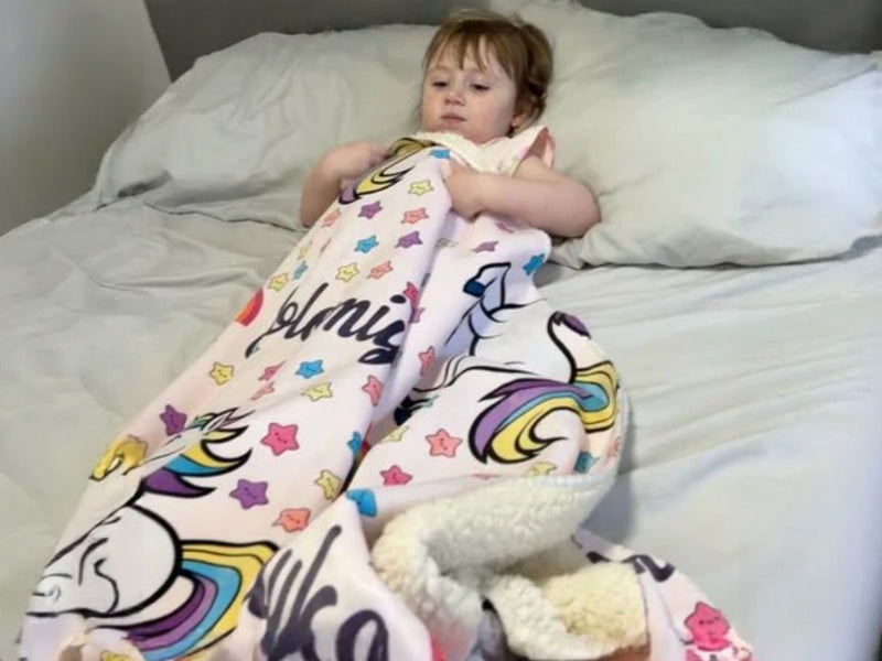 Happy child with their SnugglyMates blanket